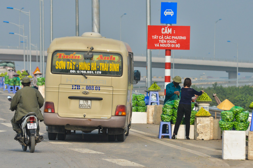 Việc lấn chiếm lòng đường làm địa điểm bán hàng như vậy là vô cùng nguy hiểm vì người điều khiển mô tô, xe máy phải di chuyển lấn sang phần đường giành cho xe ô tô, xe tải. Đây lại là tuyến đường cao tốc, các phương tiện di chuyển với vận tốc khá lớn nên khi bị lấn đường nếu không kịp xử lý thì tai nạn giao thông là điều khó tránh khỏi. (Ảnh: Minh Sơn/Vietnam+)