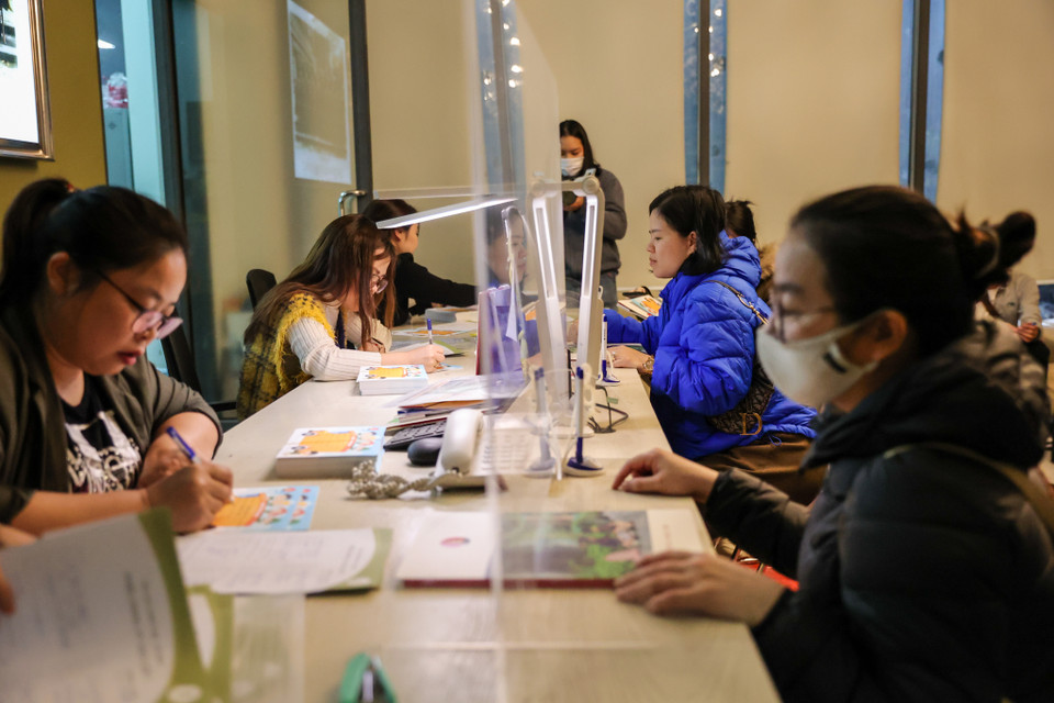 Sau khi có hồ sơ, phụ huynh điền vào phiếu đăng ký rồi nộp cho ban tuyển sinh để nhận phiếu dự trải nghiệm. Dự kiến đến 2 giờ sáng, toàn bộ phụ huynh hoàn thành hết các thủ tục. (Ảnh: Minh Sơn/Vietnam+)