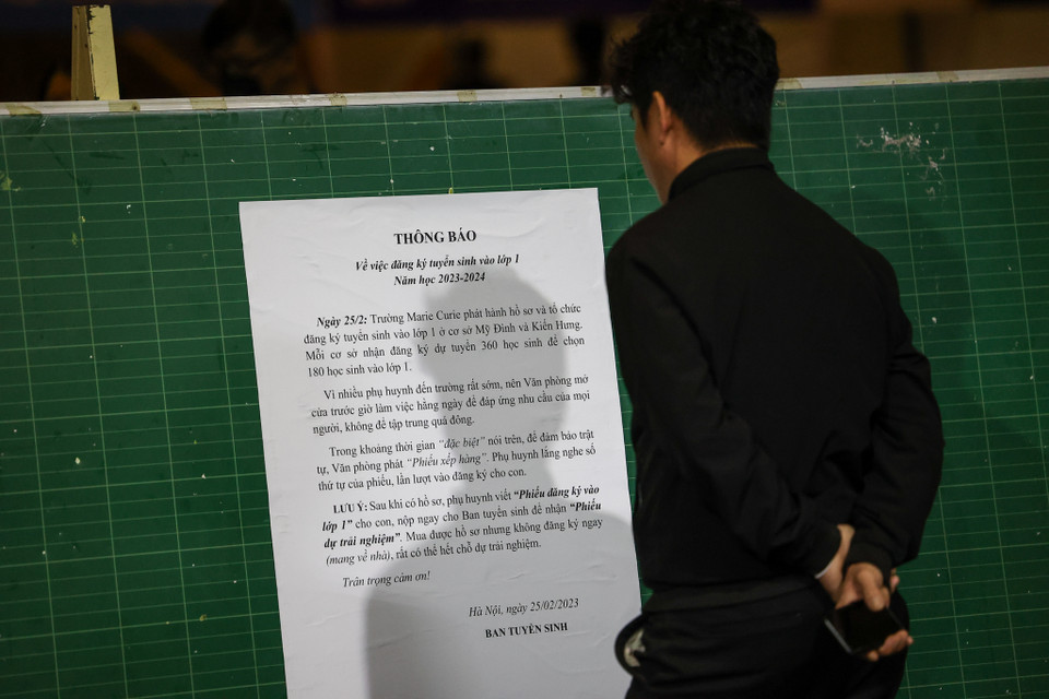 0 giờ ngày 25/2, nhà trường mới tổ chức bán hồ sơ dự tuyển vào lớp 1 nhưng nhiều phụ huynh quyết định đến sớm do sợ hết lượt. Nhà trường đã tạo điều kiện mở cửa từ tối để phụ huynh có thể vào trong sân chờ đợi, ghi tên vào số thứ tự. (Ảnh: Minh Sơn/Vietnam+)