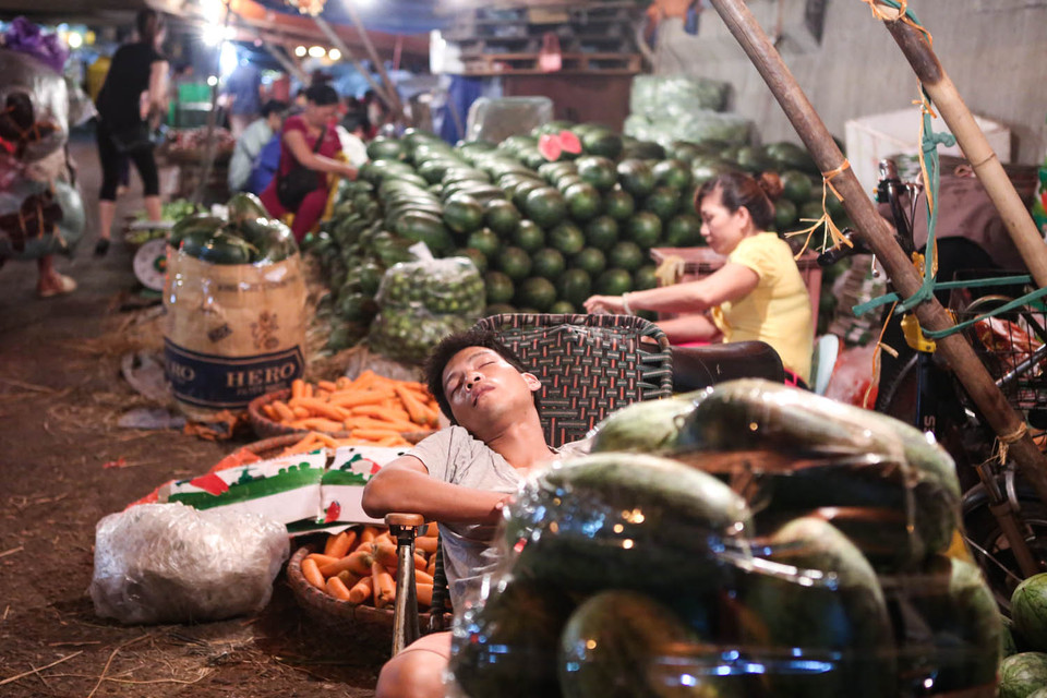 Vì là chợ đầu mối nên hoạt động 24/24 giờ, các tiểu thương phải tranh thủ chợp mắt trước khi các xe giao hàng chuyển đến. (Ảnh: Minh Sơn/Vietnam+)