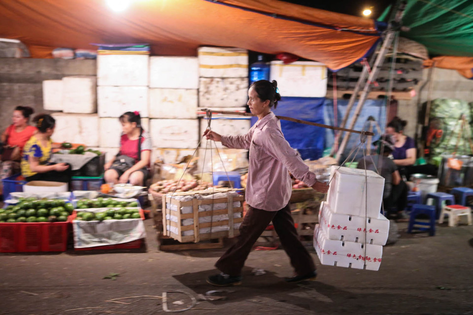 Những gánh hàng vẫn hối hả vận chuyển cho các thương lái từ bốn phương đổ về. (Ảnh: Minh Sơn/Vietnam+)