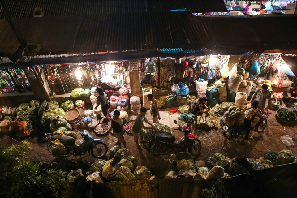 Qua hơn hai thập kỷ tồn tại, chợ đêm Long Biên đã trở thành một nét rất riêng của Thủ đô. Đó còn là nơi kiếm sống của nhiều phận người tứ xứ đổ về làm bốc vác. (Ảnh: Minh Sơn/Vietnam+)