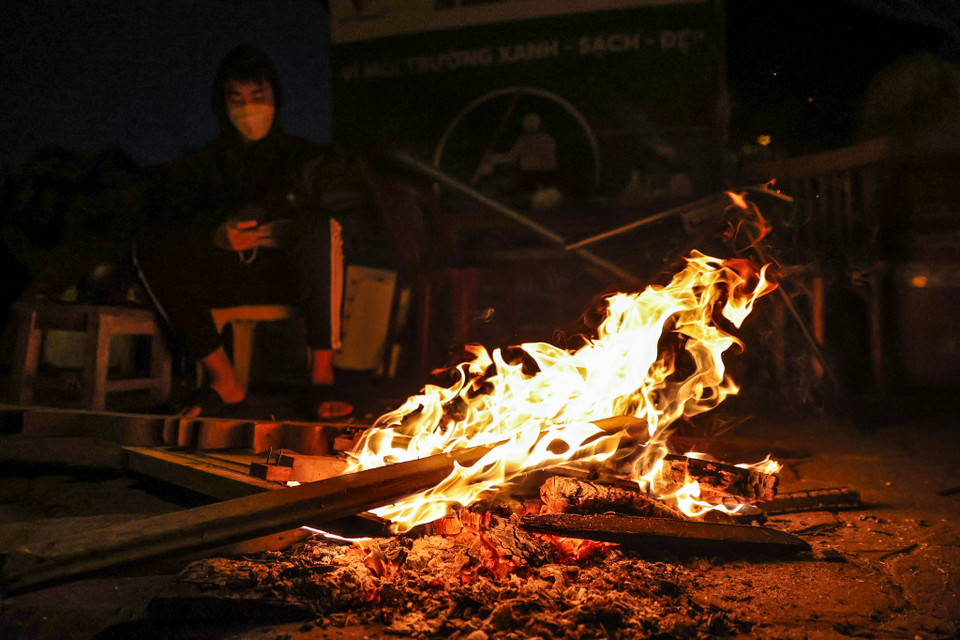 Trên nhiều tuyến phố Thủ đô như Lạc Long Quân, Nguyễn Khang, Hoàng Cầu,... người dân đốt những đống lửa lớn ngay trên vỉa hè để sưởi ấm. (Ảnh: Minh Sơn/Vietnam+)