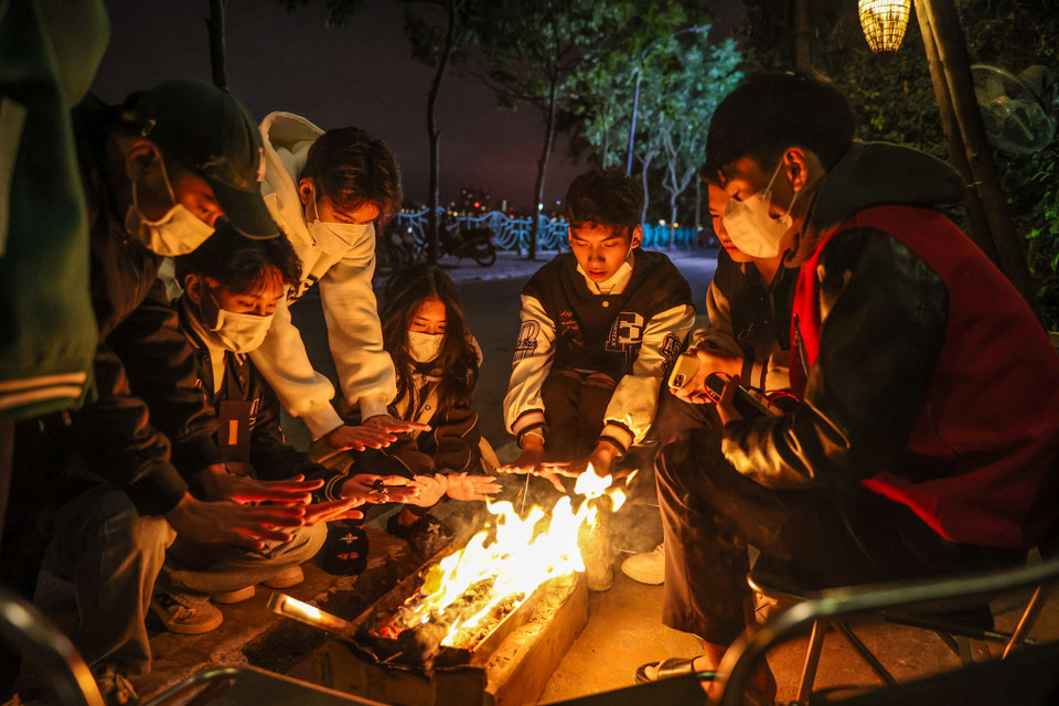 Thời điểm 1 giờ sáng 2/12, rất đông các bạn trẻ đang tụ tập tại một quán càphê ven hồ Tây để sưởi ấm. (Ảnh: Minh Sơn/Vietnam+)