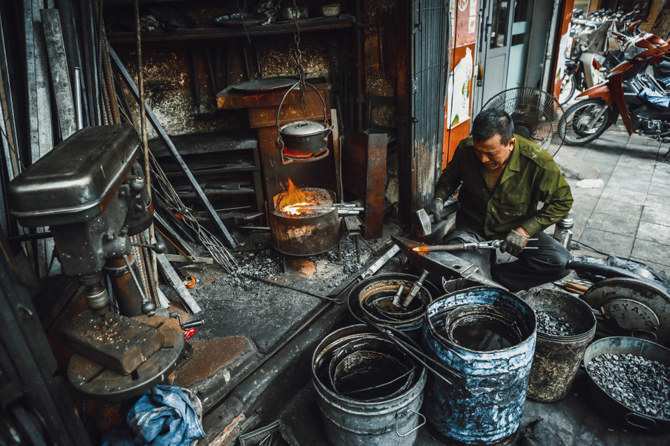 Ông Hùng chia sẻ đây là nghề rất vất vả, lò rèn và những thùng dầu sôi sùng sục lên tới hàng trăm độ giữa tiết trời nóng bức mùa hè, mùa Đông thì khô nứt nẻ. (Ảnh: Minh Sơn/Vietnam+)