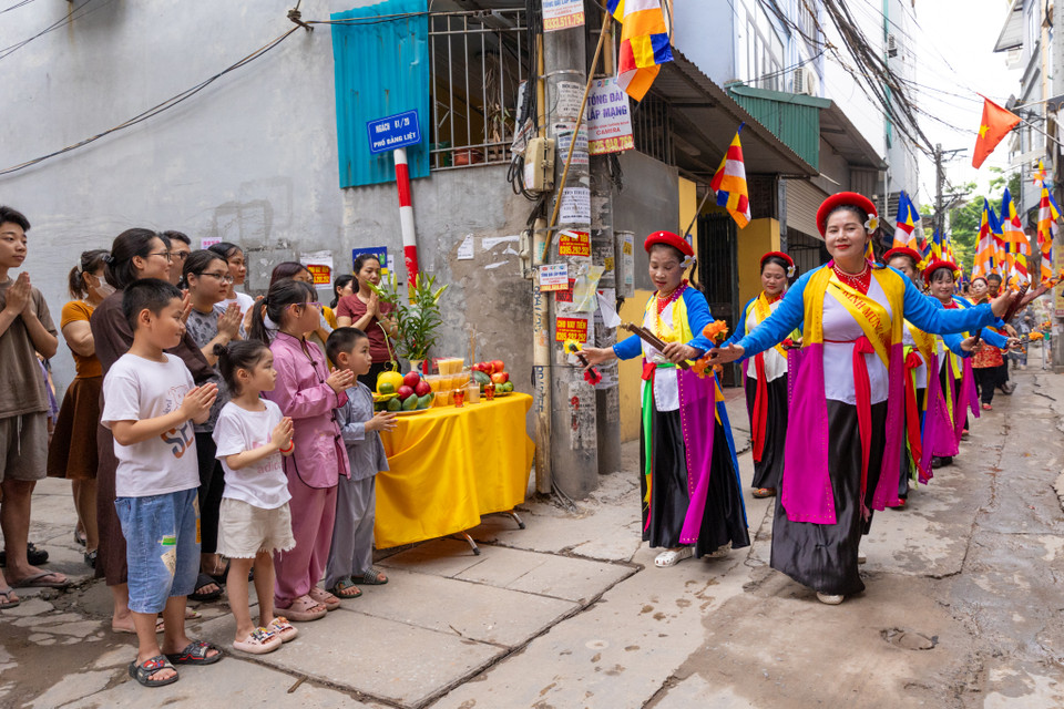 Nhiều gia đình đã đưa cả nhà ra đón chờ đoàn rước đi qua. (Ảnh: Minh Sơn/Vietnam+)