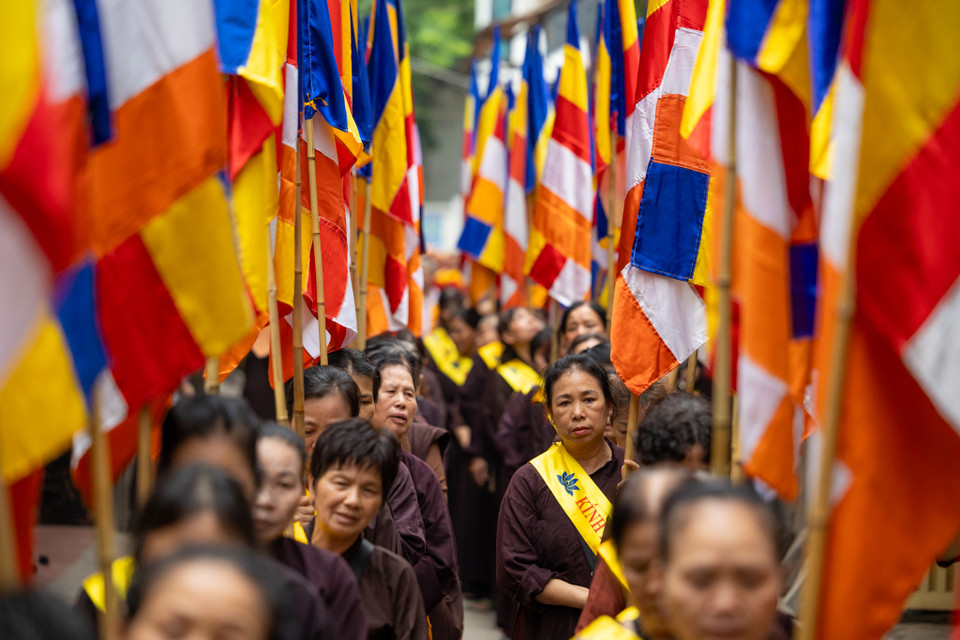 Đoàn người đi nối tiếp nhau qua từng ngõ nhỏ, tới đâu cũng thấy những bàn thờ được người dân lập sẵn đầy trang nghiêm và chắp tay thành kính trước cửa đón chào đoàn rước đi qua. (Ảnh: Minh Sơn/Vietnam+)