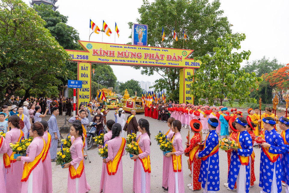 Đoàn đi bộ rước Phật di chuyển qua khắp các ngõ ngách của làng Bằng Liệt. Đi đầu là đội múa lân, múa rồng, đội cờ, đội phướn, tiếp theo là kiệu hoa rước Phật, đội bát âm, đội múa sen hoà trong tiếng niệm Phật âm tạo nên không khí đầy thiêng liêng. (Ảnh: Minh Sơn/Vietnam+)