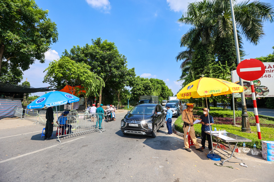 Tại chốt kiểm soát dịch lối từ khu đô thị Ecopark (Hưng Yên) vào Hà Nội, lực lượng liên ngành tập trung kiểm soát các phương tiện ra vào. (Ảnh: Minh Sơn/Vietnam+)