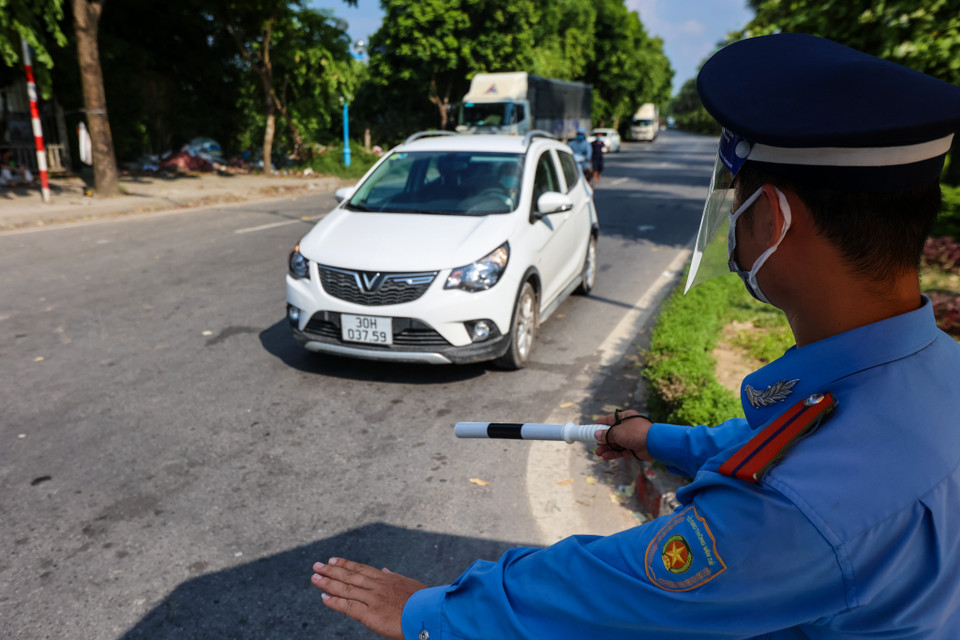 Tại chốt kiểm soát, ngoài xe chở hàng, các ôtô cá nhân, người đi xe máy cũng phải cung cấp các giấy tờ cần thiết và kiểm soát thân nhiệt trước khi được phép di chuyển qua. (Ảnh: Minh Sơn/Vietnam+)
