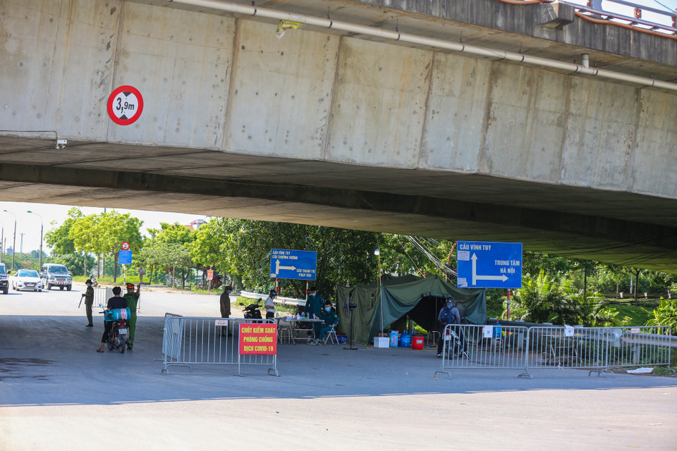 Tại chốt kiểm soát khu vực chân cầu Thanh Trì, lực lượng chức năng liên tục yêu cầu nhiều xe phải quay đầu vì không có đủ điều kiện ra vào thành phố. (Ảnh: Minh Sơn/Vietnam+)