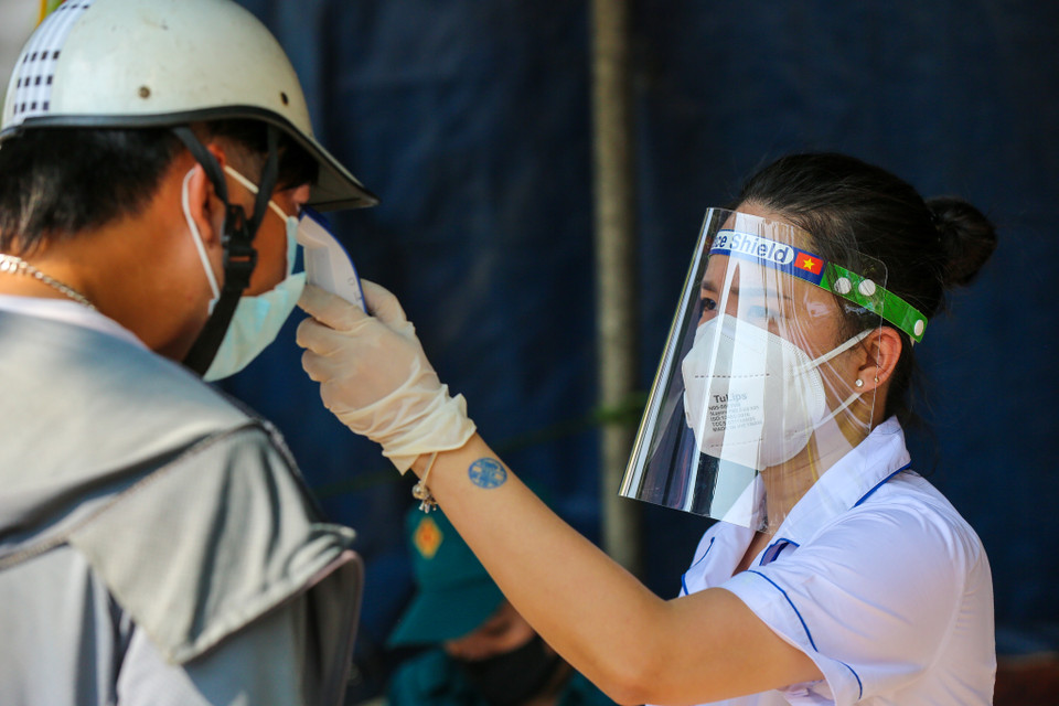 Khi đủ điều kiện, người dân cũng phải khai báo y tế với lực lượng chức năng và được đóng dấu trên tay để vào nội đô. (Ảnh: Minh Sơn/Vietnam+)