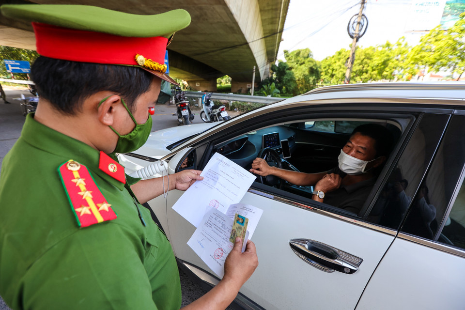 Những người dân và phương tiện phải khai báo y tế, đo thân thiệt mới được ra vào thành phố. (Ảnh: Minh Sơn/Vietnam+)