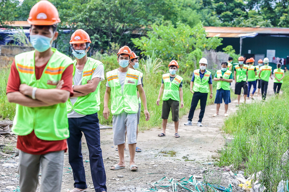 Những công nhân tại Phú La, Hà Đông (Hà Nội) đảm bảo giãn cách khi xếp hàng nhận các suất ăn miễn phí. (Ảnh: PV/Vietnam+)