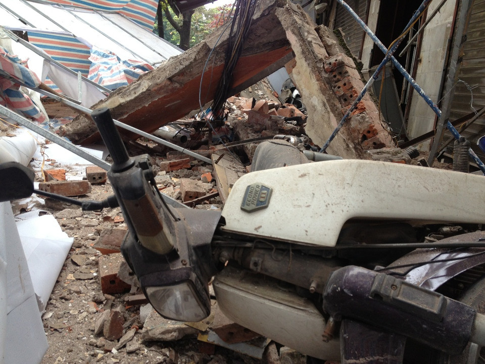 Phần mái tôn của nhà sập ngay cạnh quán ăn đang đông khách. Nhiều người thấy sự việc đã hốt hoảng bỏ chạy. (Ảnh Minh Sơn/Vietnam+)