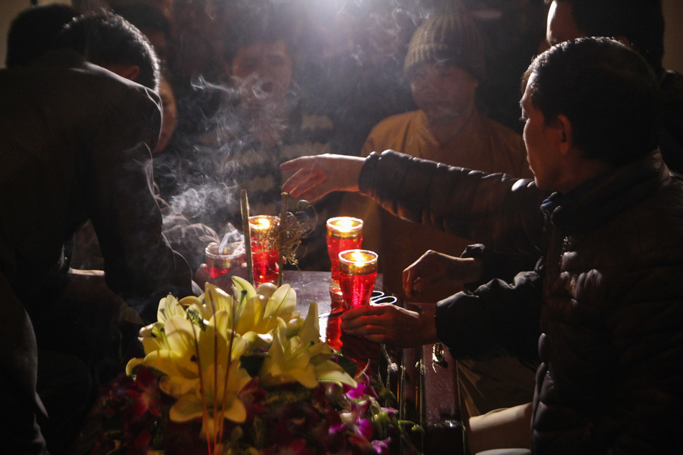 Những ngọn nến được thắp lên cùng tiếng niệm của các tăng ni Phật tử địa phương cầu mong cho linh hồn anh Đạt sớm siêu thoát. (Ảnh Minh Sơn/Vietnam+)