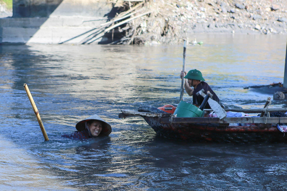 Có nơi nước sâu hàng mét nên người dân phải chèo thuyền ra để mót than. (Ảnh: Minh Sơn/Vietnam+)