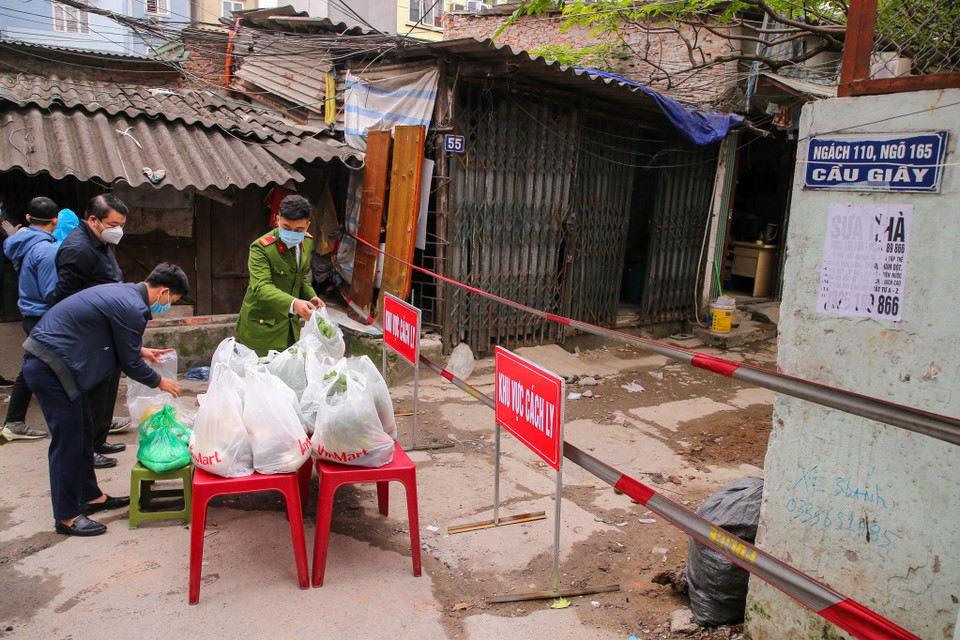 Trong những ngày thực hiện việc cách ly y tế, lực lượng chức năng vừa duy trì tổ công tác trực chốt vừa cung cấp thực phẩm miễn phí cho các hộ dân nơi đây. (Ảnh: Minh Sơn/Vietnam+)