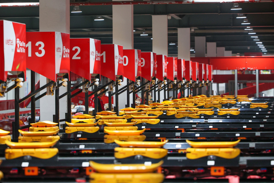Còn robot AGV là công nghệ robot hiện đại được nhiều đơn vị logistics lớn trên thế giới như China Post, Amazon… sử dụng để chia chọn các loại hàng hóa nhẹ, mỏng, hàng có hình dáng đặc thù, tròn lăn, thích hợp với hàng hóa trên sàn thương mại điện tử. Hiện tại, Viettel Post là công ty logistics đầu tiên tại Việt Nam triển khai công nghệ robot AGV. (Ảnh: Minh Sơn/Vietnam+)