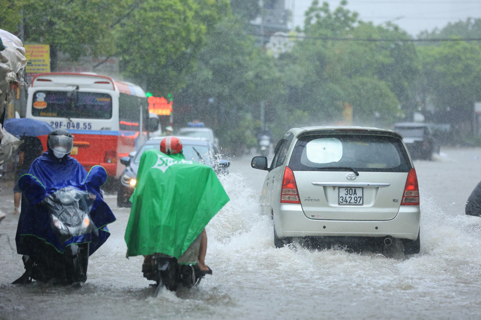 Ngay sau đó, khoảng 7 giờ sáng cơn mưa dông ập tới khiến người đi đường không kịp trở tay. (Ảnh: Hoài Nam/Vietnam+)