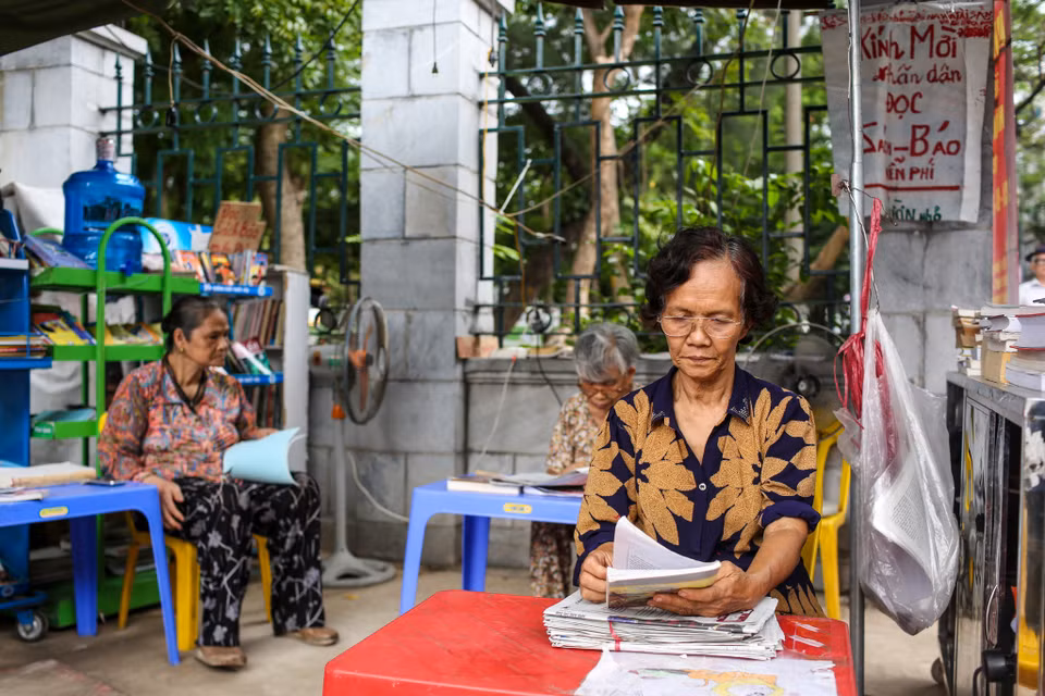 Những ngày trời nắng gay gắt, tại Gò Đống Đa (Hà Nội) người ta đã quen với hình ảnh một bà lão mang sách, báo miễn phí niềm nở mời người qua lại đọc. (Ảnh: Minh Sơn/Vietnam)