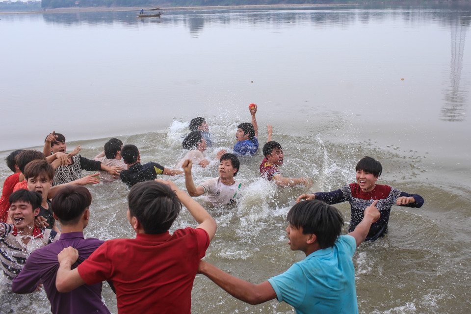 Mặc dù theo luật chơi, người nào chỉ cần mang quả phết ra khỏi ranh giới của các cây nêu thì sẽ giành chiến thắng, tuy nhiên cuộc chơi quyết liệt có thể diễn ra đến giữa sông. (Ảnh: Minh Sơn/Vietnam+)