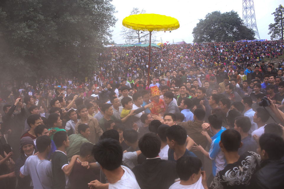 Phải rất khó khăn, cụ chủ tế mới bước ra được bãi cướp phết trong sự bảo vệ của hàng chục thanh niên trai tráng. (Ảnh: Minh Sơn/Vietnam+)