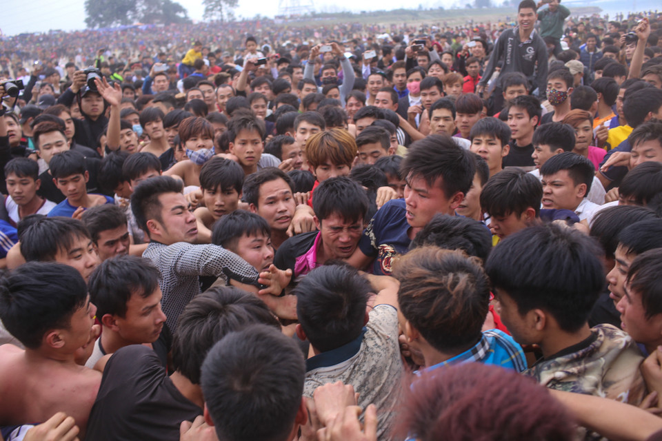 Ai cũng muốn cướp được quả phết may mắn đem về nhà hay chỉ là được chạm vào phết nên cuộc chơi diễn ra vô cùng quyết liệt và căng thẳng. (Ảnh: Minh Sơn/Vietnam+)