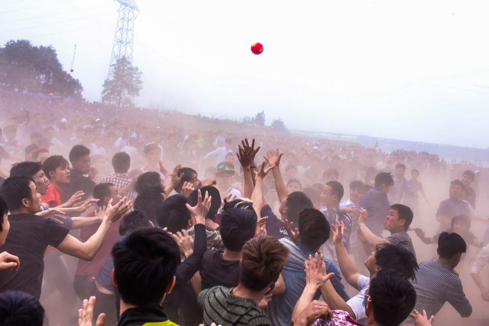 Sau khi quả phết được thả xuống, cả ngàn thanh niên trai tráng ngay lập tức xông vào tranh cướp. (Ảnh: Minh Sơn/Vietnam+)