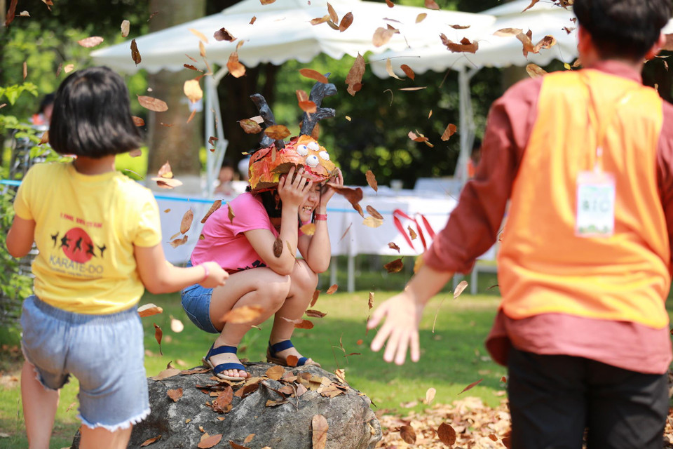 Được ôm hàng đống lá rồi tung lên thật cao để chiêm ngưỡng những 'cơn lốc lá vàng' chao liệng là một trải nghiệm khó quên của các em. (Ảnh: PV/Vietnam+)
