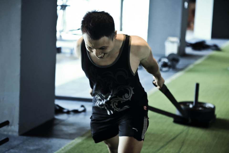 Người tập sẽ được huấn luyện viên chỉ dẫn cho các bài tập như kéo, đẩy tạ để tăng cường sức mạnh và sức bền cơ bắp. (Ảnh: Minh Sơn/Vietnam+)