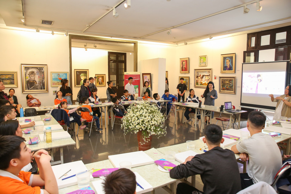 Nữ hoạ sỹ Văn Dương Thành và bốn bạn Nguyễn Quang Minh, Nguyễn Linh Chi, Trần Khánh Linh và Lê Châu Anh cùng hướng dẫn các bạn nhỏ đến từ trường Phổ thông Cơ sở Dân lập Dạy trẻ câm điếc Hà Nội tập vẽ những bức tranh đầy sinh động. (Ảnh: Minh Sơn/Vietnam+)