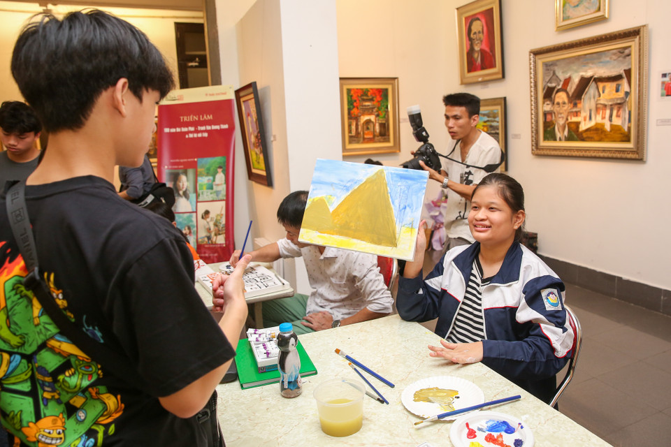 Một bạn nhỏ hào hứng khoe bức tranh mình vừa hoàn thành. (Ảnh: Minh Sơn/Vietnam+)
