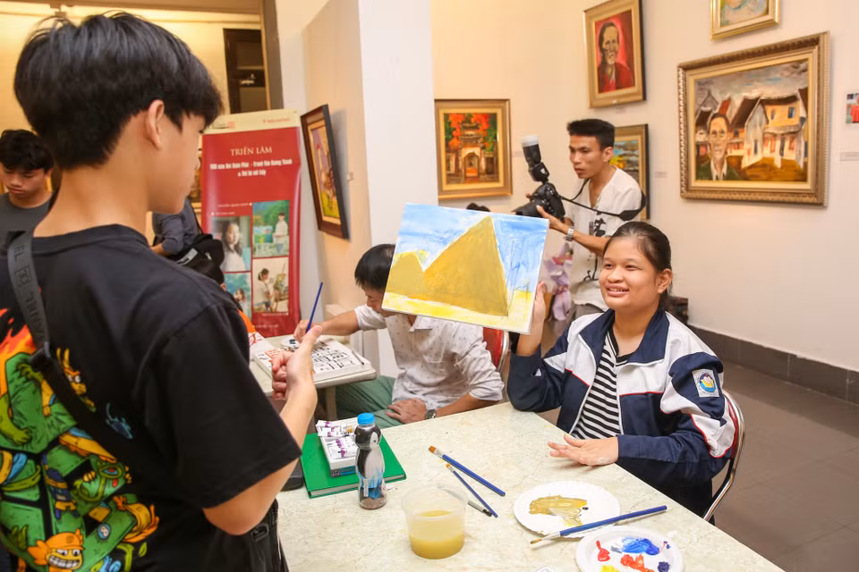 Một bạn nhỏ hào hứng khoe bức tranh mình vừa hoàn thành. (Ảnh: Minh Sơn/Vietnam+)