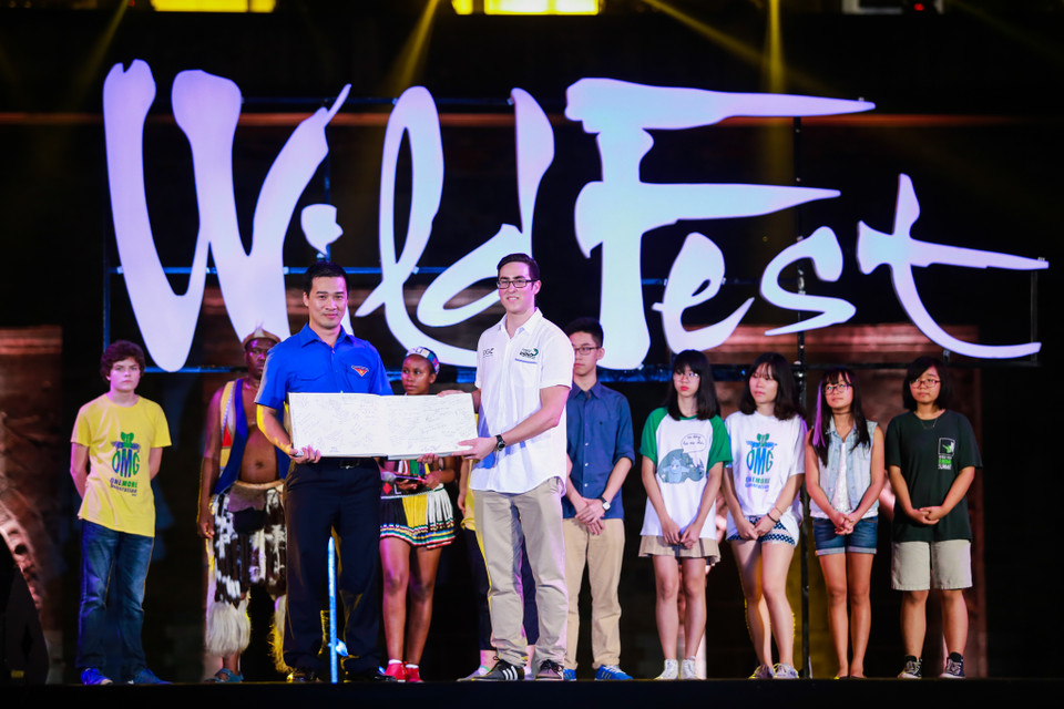 Ông Vỹ Minh Lý, Giám đốc Trung tâm tình nguyện Việt Nam vui mừng nhận cuốn sách với những chữ ký cam kết hành động bảo vệ loài tê giác của mọi người trên khắp thế giới. (Ảnh: Minh Sơn/Vietnam+)