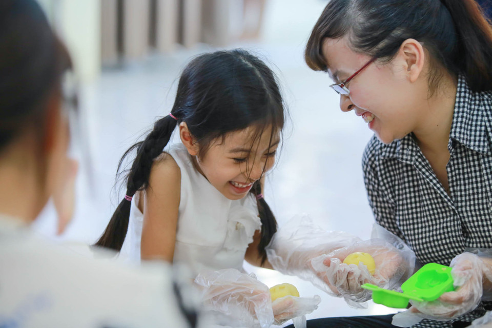 Cô bé Hạnh Phương, lớp 1A4 thích thú khi chiếc bánh thành hình yêu thích của mình. (Ảnh: Minh Sơn/Vietnam+)