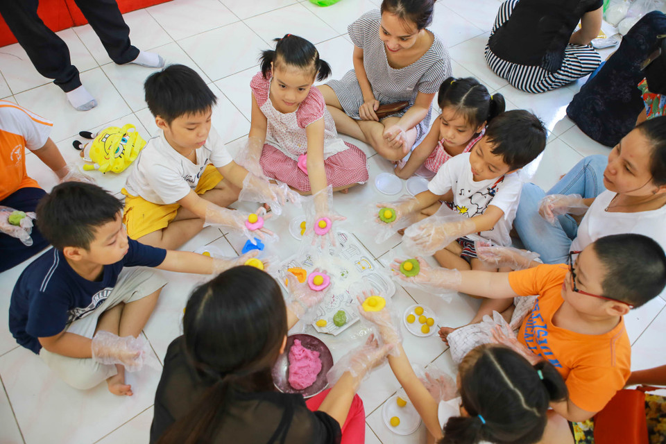 Cha mẹ sẽ chuẩn bị sẵn nguyên vật liệu như bột mì, nhân đậu xanh, khuôn bánh,…. Các bé chỉ việc cán bột ra thật mỏng, vo tròn nhân đậu xanh rồi ép vào khuôn. (Ảnh: Minh Sơn/Vietnam+)