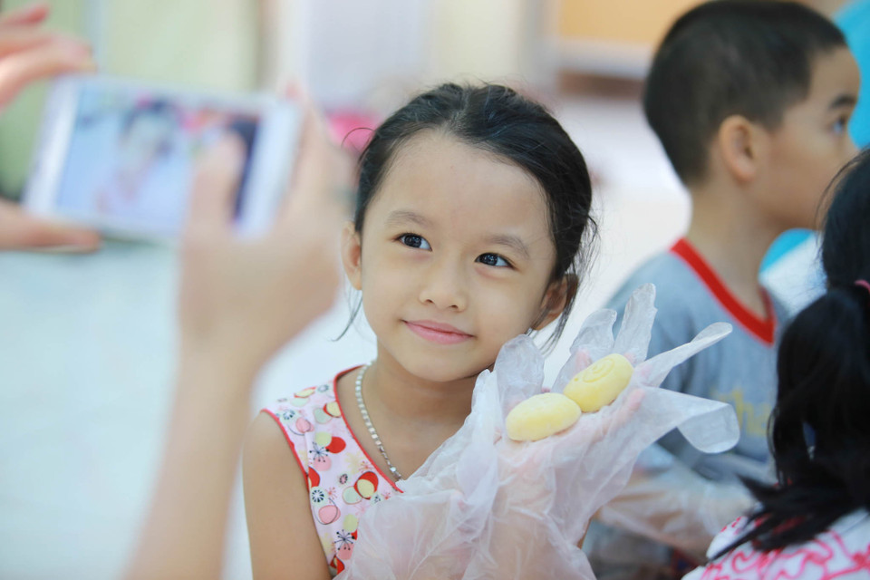 ‘Chiếc bánh Trung thu do chính tay các bé làm để tặng ông bà, tặng bố mẹ hay chia sẻ cho những mảnh đời bất hạnh sẽ giúp các con hiểu được cuộc sống, giá trị của văn hóa’. Anh Phú, một phụ huynh chia sẻ. (Ảnh: Minh Sơn/Vietnam+)