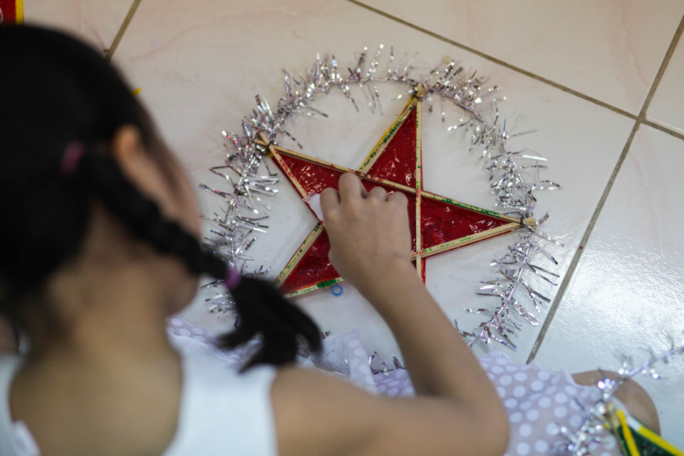 Từ khâu tạo hình, dán giấy, lắp đèn,… các bé đều tự tay làm hết. Phụ huynh chỉ đứng ngoài hướng dẫn các con. (Ảnh: Minh Sơn/Vietnam+)