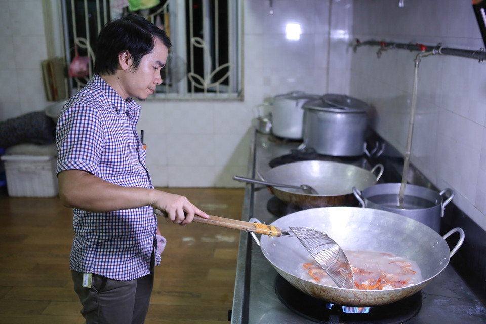 Nếu cơm nấu sớm để đến trưa hôm sau là thiu nên các tình nguyện viên của chương trình đã chấp nhận thức nguyên đêm để chuẩn bị. (Ảnh: Minh Sơn/Vietnam+)