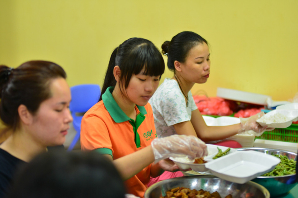 Trước khi chuyển đi, tình nguyện viên sẽ chia cơm ra các phần bằng nhau. (Ảnh: Minh Sơn/Vietnam+)