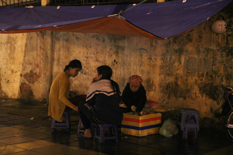 Những quán trà đá vỉa hè mọi tối nhộn nhịp nhưng giờ chỉ còn 3 mẹ con ngồi với nhau. (Ảnh: Minh Sơn/Vietnam+)