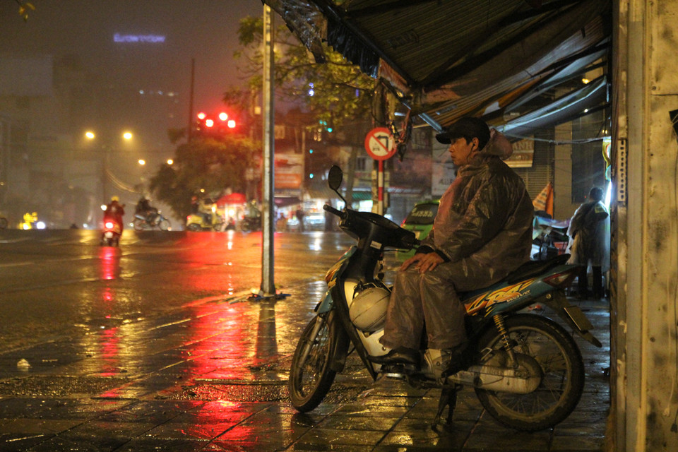  23 giờ đêm, Hà Nội vắng lặng trong cái giá lạnh tê người, anh xe ôm vẫn kiên trì ngồi đợi. (Ảnh: Minh Sơn/Vietnam+)