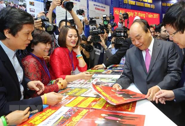 Thủ tướng Nguyễn Xuân Phúc thăm gian trưng bày của Liên Chi hội Nhà báo Thông tấn xã Việt Nam. (Ảnh: TTXVN)