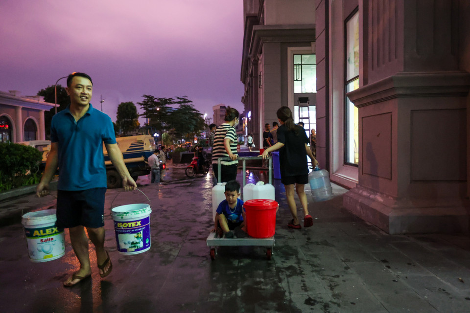 Đến chiều tối 23/9, tình trạng các hộ dân phải mang đủ loại bình chứa, can, xô để chở/trữ nước về dùng vẫn diễn ra tấp nập. (Ảnh: Minh Sơn/Vietnam+)