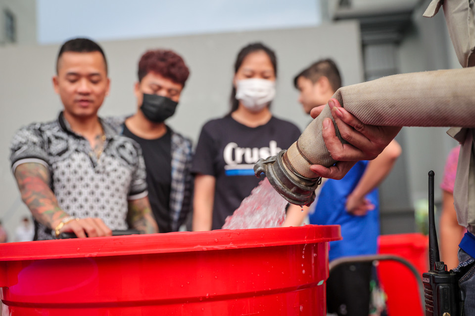 Tình trạng các cư dân khu chung cư Hateco phải mang xô chậu, can đi chở nước từ sảnh lên là khá phổ biến. (Ảnh: Minh Sơn/Vietnam+)