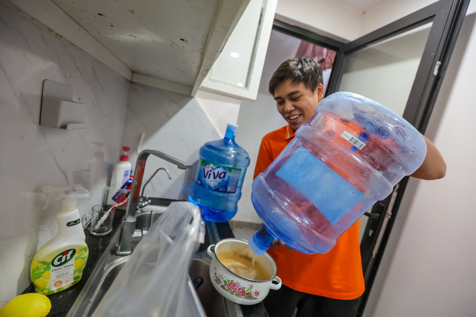 Anh Hoàng Trí Công, một người dân sống tại Hateco cho biết, gia đình nhận được thông báo tạm ngừng cấp nước từ rạng sáng 22/9. Anh Công đã mua đến 4 bình nước sạch 18 lít để dùng. (Ảnh: Minh Sơn/Vietnam+)