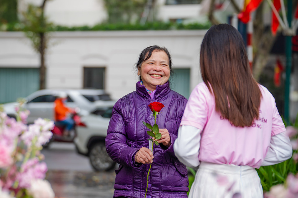 Những cô lao công, ông bà già, cô bán hàng rong, người khuyết tật, chú đạp xích lô đã rất bất ngờ và xúc động vì được tặng hoa trong ngày đặc biệt này. (Ảnh: PV/Vietnam+)