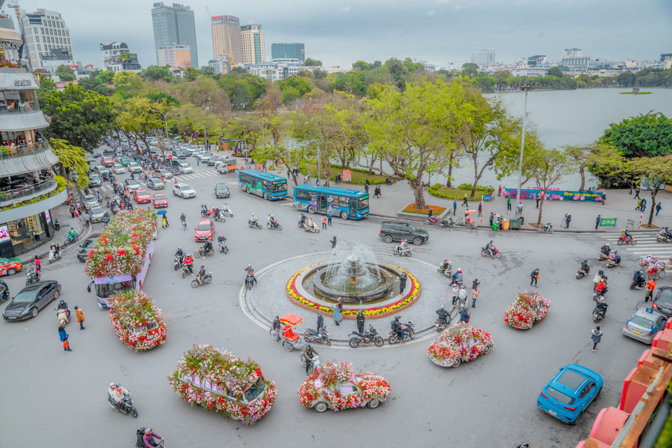 Nhiều người dân Hà Nội không khỏi thích thú và ngạc nhiên khi trên phố bỗng trở nên xinh đẹp, rực rỡ với sự xuất hiện của những chiếc xe hoa di động. (Ảnh: PV/Vietnam+)