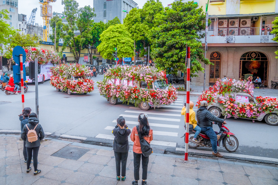 Đặc biệt, đoàn xe đã dừng tại hàng chục điểm để tặng những đóa hoa tươi thắm cho người dân Hà Nội. (Ảnh: PV/Vietnam+)